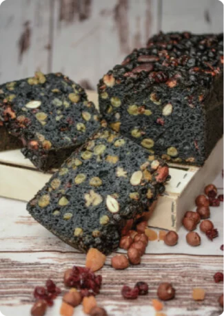 PAIN KASA - HAT'S BOULANGERIE Pain à base de farine de riz bio, de levain naturel bio et de charbon végétal. C’est un pain sans gluten, agrémenté d’un savoureux mélange de fruits secs.